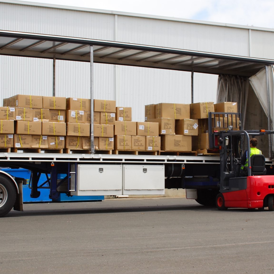Forklift loading boxes onto a truck.